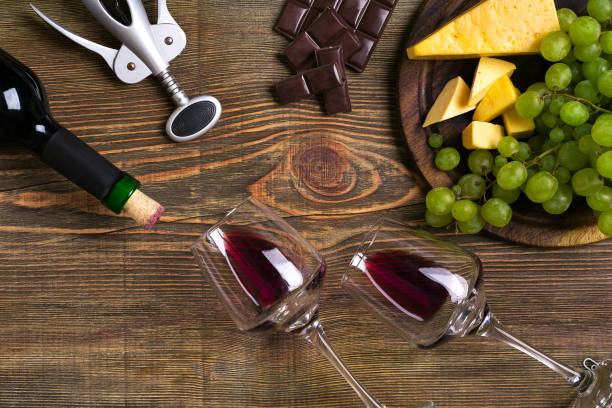istock Red wine bottle, grape, cheese and glasses over wooden table. Top view with copy space 824324128