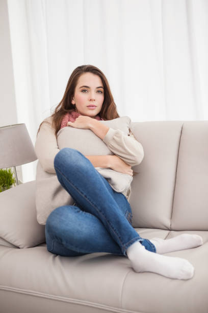 istock Pretty brunette hugging a cushion 824333360