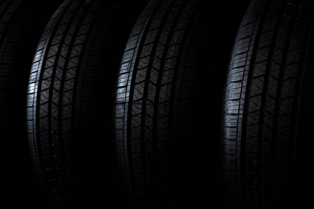 istock Four new winter tires with modern tread on black background 824337178
