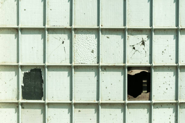 istock Old square industrial windows from abandoned factory painted in white. 824338032