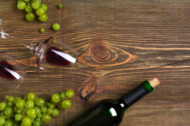 istock Red wine bottle, grape and glasses over wooden table. Top view with copy space 824341774