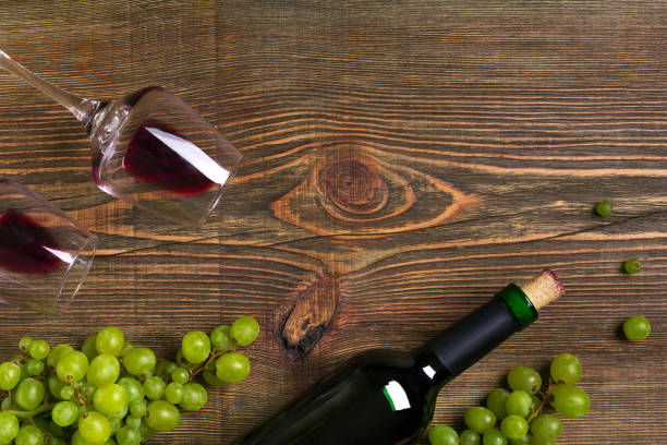 istock Red wine bottle, grape and glasses over wooden table. Top view with copy space 824341998