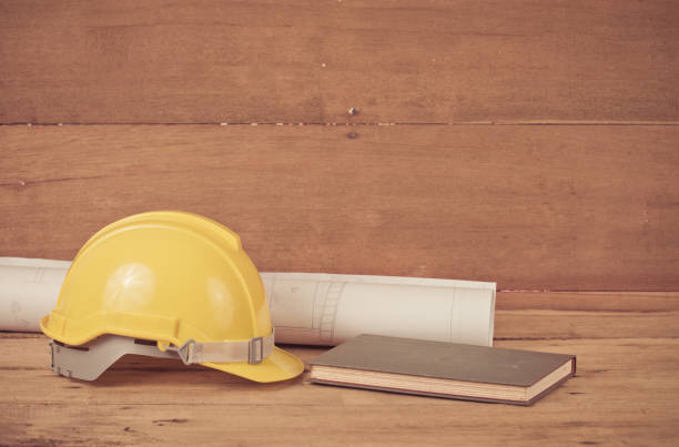 istock yellow construction safety helmet on wood 824344348