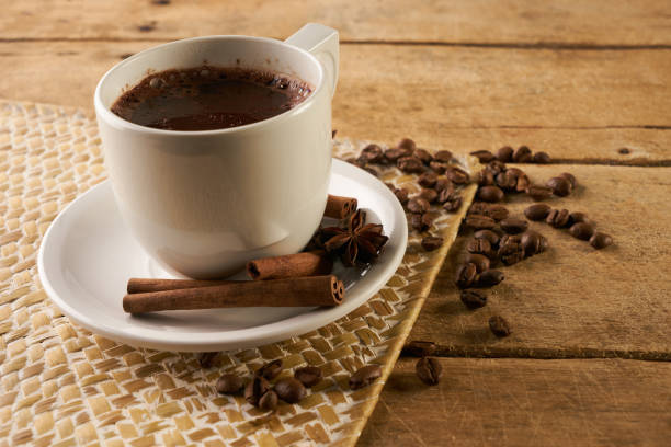 istock Coffee cup and coffee beans with cinnamon sticks and anise on old rustic wooden table 824355888