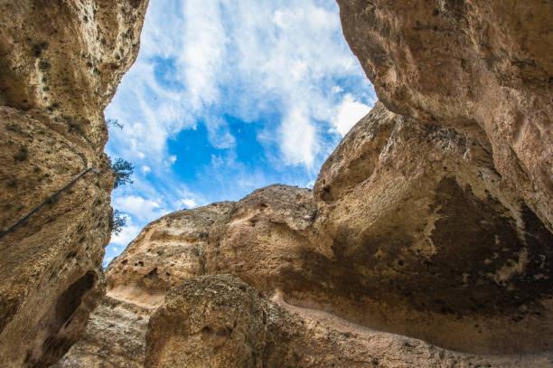 istock Blue sky with clouds seen fron among the rocks 824356016