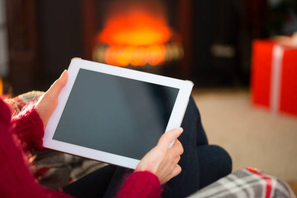 istock Woman in jumper using tablet at christmas 824378062