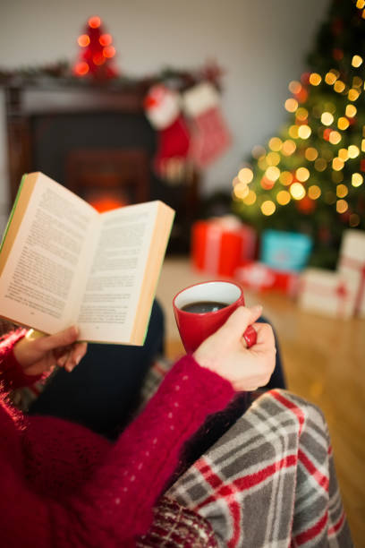 istock Woman in jumper reading and drinking coffee 824378322