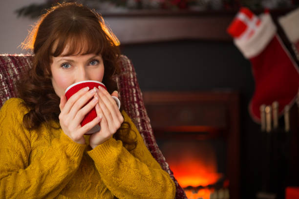 istock Smiling redhead drinking hot drink at christmas 824378500
