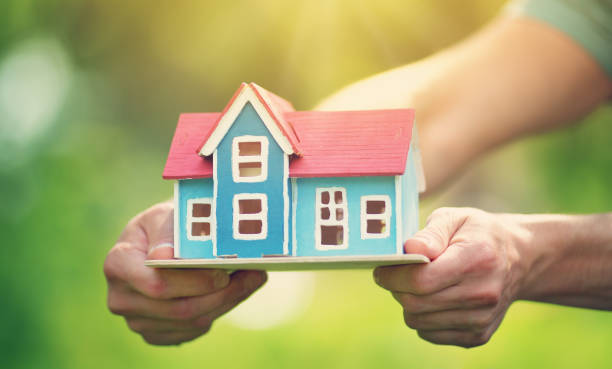 istock man hands holding wooden house 824378944
