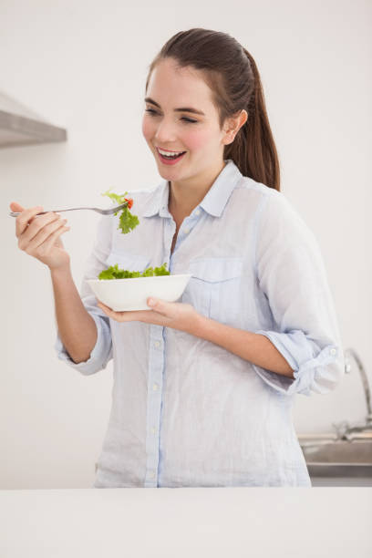 istock Pretty brunette eating bowl of salad 824387852