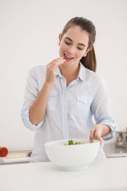 istock Pretty brunette eating bowl of salad 824389996