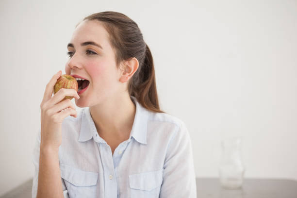 istock Pretty brunette eating an apple 824392628