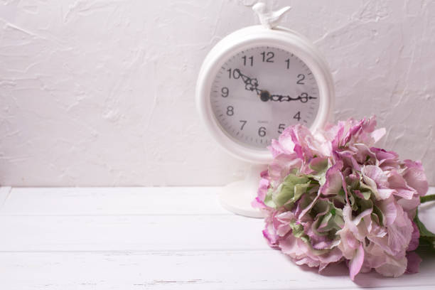 istock Postcard with pink hydrangea flowers and clock on light textured background. 824393086