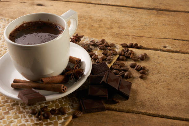 istock Coffee cup and coffee beans with cinnamon sticks and anise on old rustic wooden table 824393316