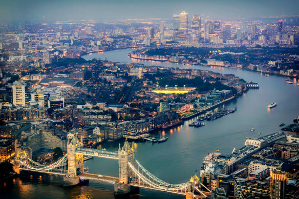 vue aérienne de tower bridge et de canary wharf dans la nuit - london england aerial view skyscraper mid air photos et images de collection