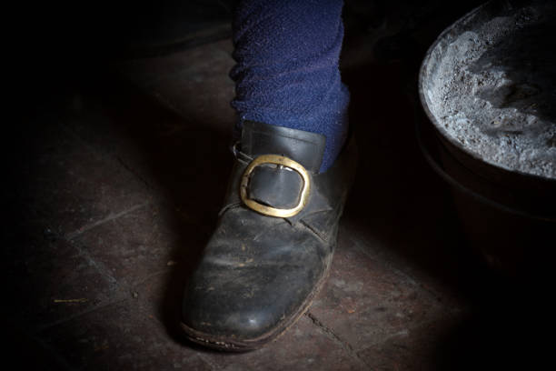 A man displays a set of handmade shoes that show what would have been worn in rural Lancaster County in the 19th century.