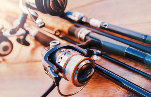 fishing tackle on a old wooden table. sport and recreation concept - carretel de pesca imagens e fotografias de stock