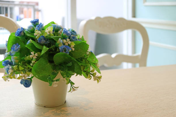 Waitress working at a restaurant and setting a table putting beautiful flowers