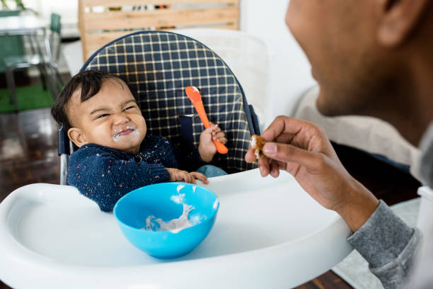 istock Father feeding baby son and having fun 824430254