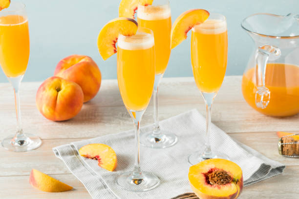 Sweet Bubbly Peach Bellini Mimosa Sweet Bubbly Peach Bellini Mimosa with Champagne bellini cocktail stock pictures, royalty-free photos & images