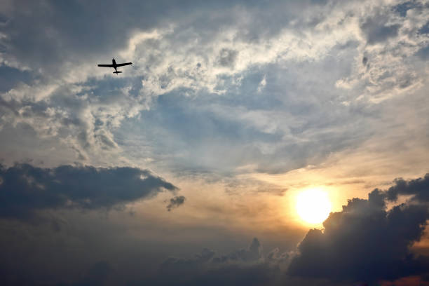 istock light aircraft flying in the sky at sunset 824552120