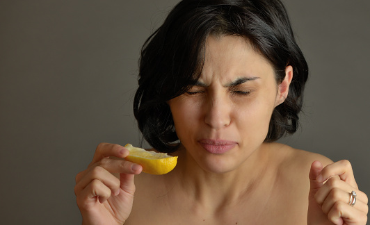 Woman eating lemon and making silly faces