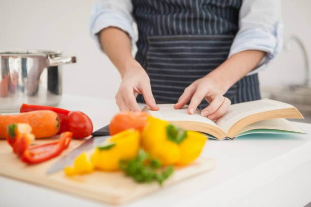 istock Woman following a recipe in book 824556144