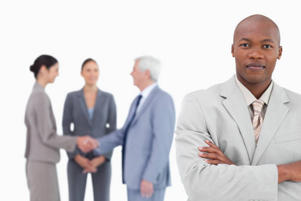 istock Businessman with arms folded and trading partners behind him 824559092