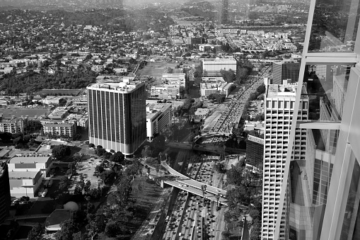 A black and white snapshot of traffic moving along a freeway in the middle of Los Angeles, California.