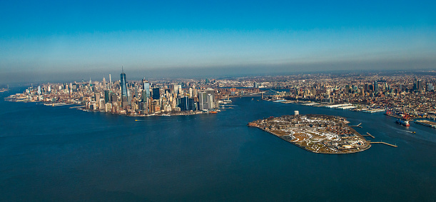 Aerial view of New York City skyline and Governors Island through helicopter. Horizontal composition. Helicopter moving Manhattan via Hudson river. Financial district appears fully in Lower Manhattan. Image taken with Nikon D800 and developed from Raw format.