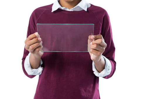 Mid-section of teenage boy using glass digital tablet against white background