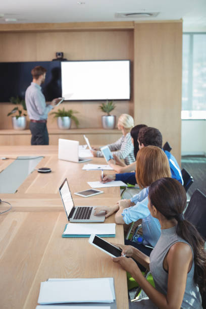 istock Business people using laptop and digital tablets at conference table during meeting 824563882