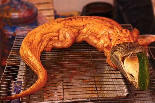 bbq roasted crocodile on grid close up photo