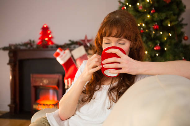istock Pretty redhead sitting on couch drinking hot chocolate 824568818