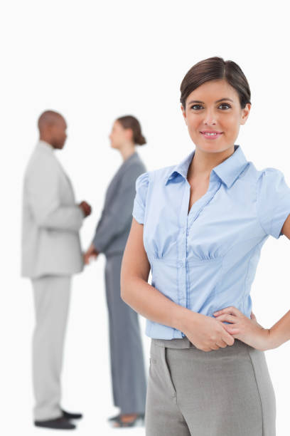 istock Smiling tradeswoman with talking colleagues behind her 824573618