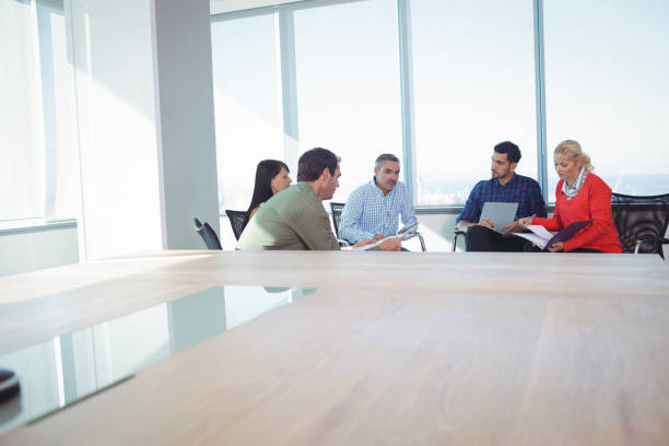 istock Business colleagues discussing while sitting against window at office 824580274