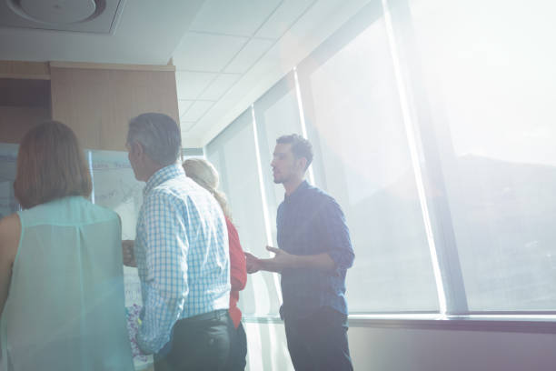 istock Business colleagues discussing at office during sunny day 824580370