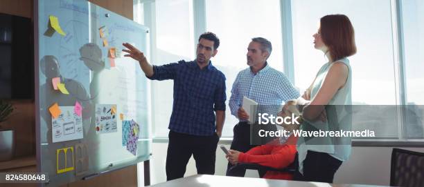 Young Businessman Discussing With Colleagues At Office Stock Photo - Download Image Now