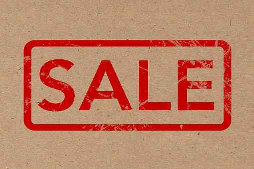 Red Rubber Sale Grunge Stamp over Cardboard extreme closeup. 3d Rendering.