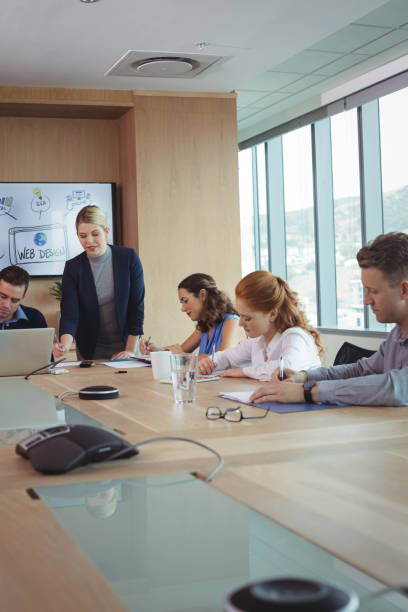 istock Young businesswoman with team working at conference table 824588372