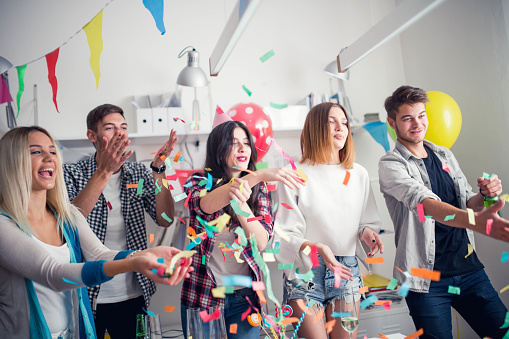 Group of young colleagues celebrating birthday party in modern office