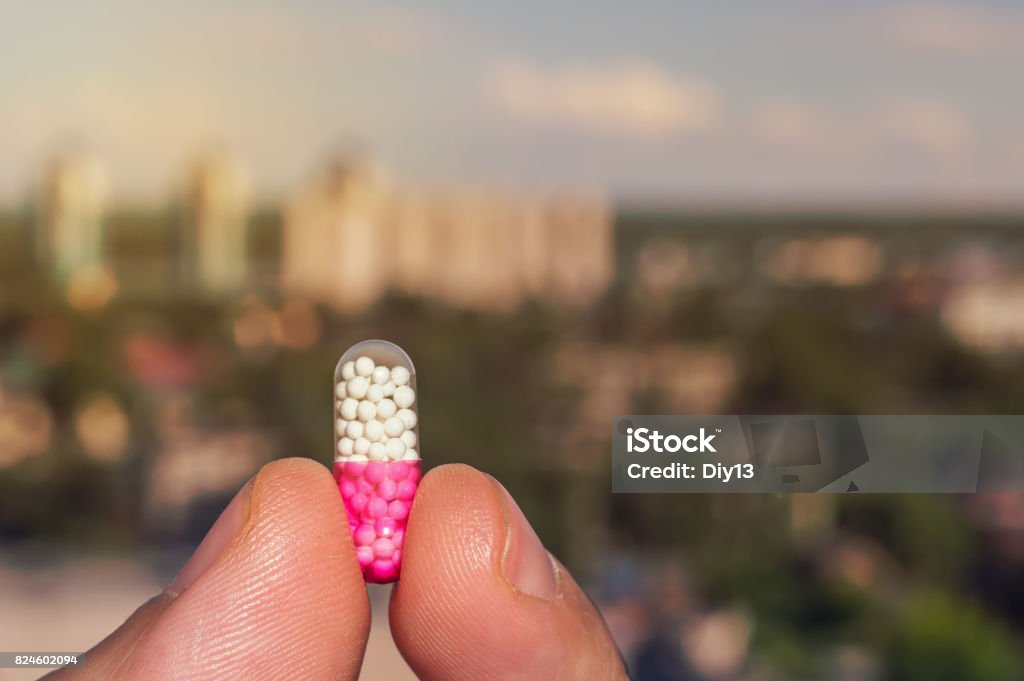 Tablet in the hands of a person on the background Tablet in the hands of a person on the background of the urban landscape. Capsule - Medicine Stock Photo