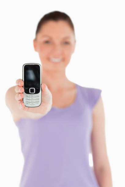 istock Beautiful woman holding and showing her phone while standing 824602676