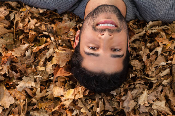 istock Overhead of man lying on autumn leaves 824603770