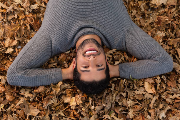 istock Overhead of man lying on autumn leaves 824603826
