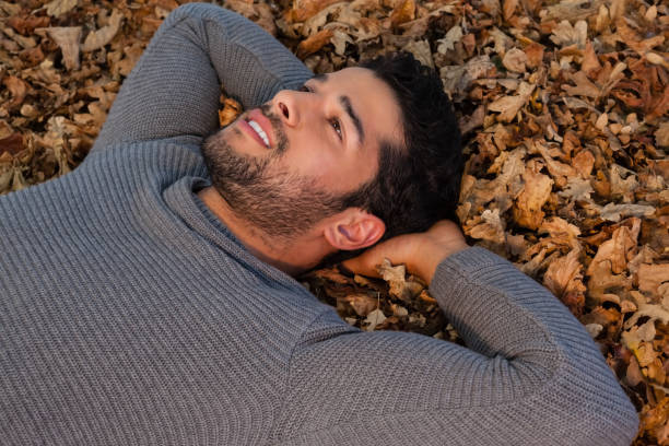 istock Overhead of man lying on autumn leaves 824603940