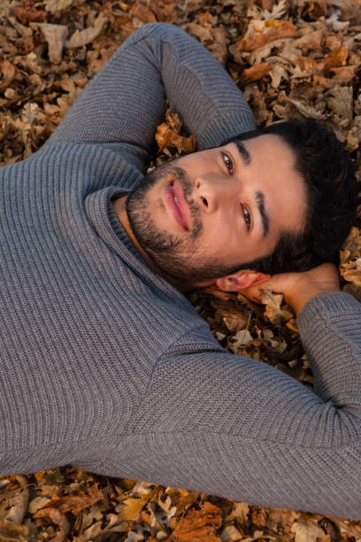 istock Overhead of man lying on autumn leaves 824603960