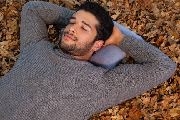 istock Overhead of man lying on autumn leaves 824603968