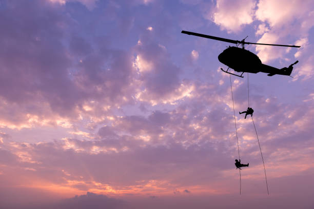 istock soldiers rescue helicopter operations on sunset sky background. 824605602