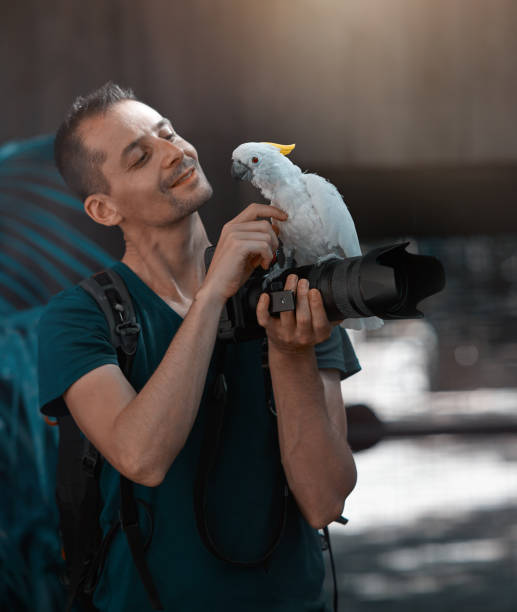 istock photographer with his parrot friend 824608080